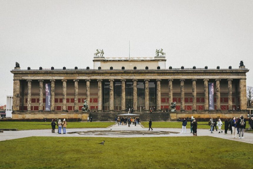 ddr museum berlin - Front view of the Altes Museum in Berlin with people and green lawn.