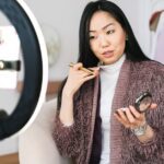 imke riedebusch - Beauty vlogger demonstrating makeup tips using a ring light during live stream.