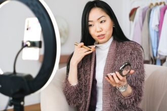 imke riedebusch - Beauty vlogger demonstrating makeup tips using a ring light during live stream.
