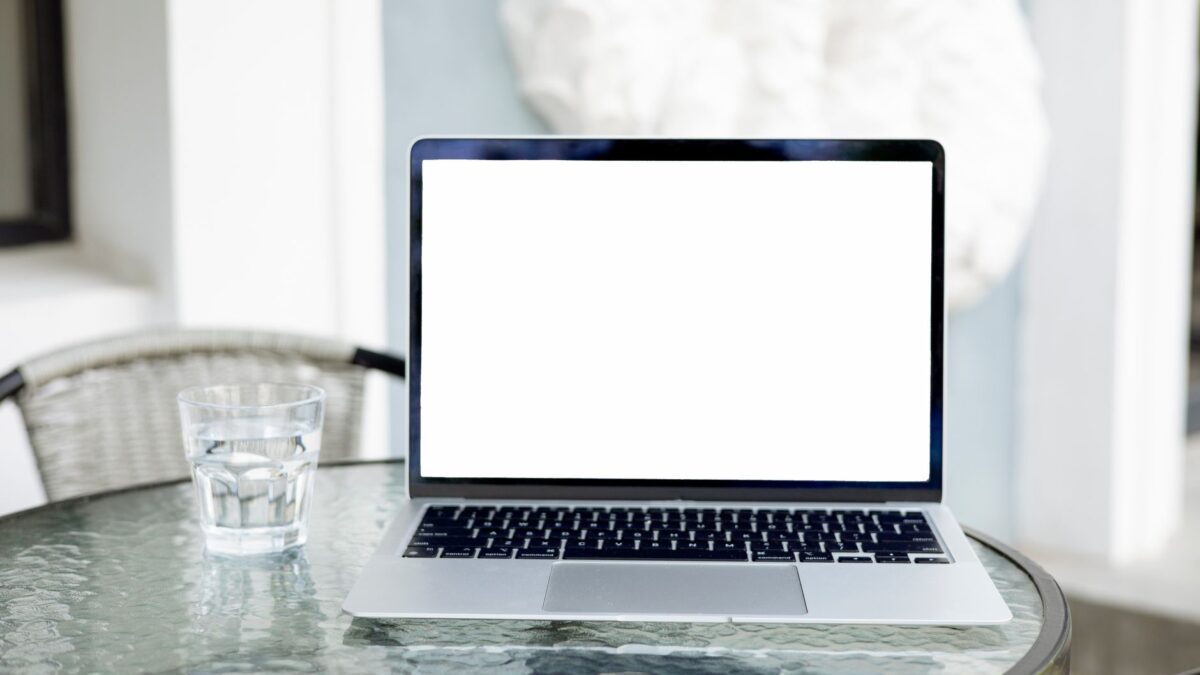 Mobiler WLAN-Router neben Laptop und Smartphone auf einem Tisch