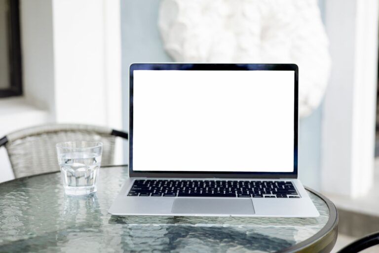 Mobiler WLAN-Router neben Laptop und Smartphone auf einem Tisch